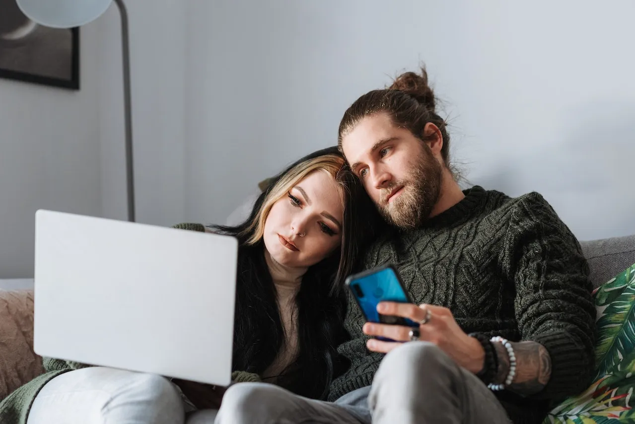 Travel couple using laptop on couch